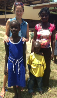 Volunteer with family outside the school in Ghana.