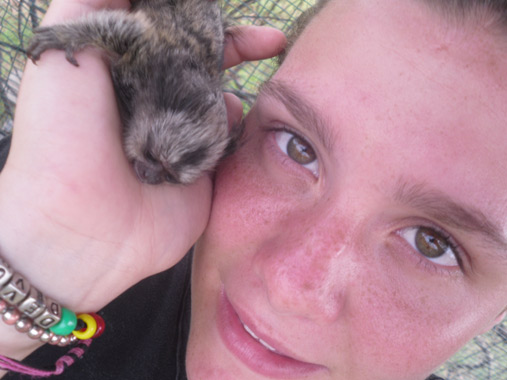 Volunteer holds monkey in hand at rescue centre in South Africa