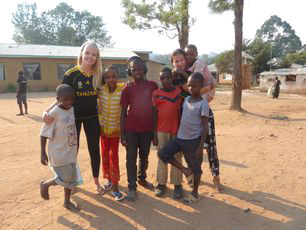tanzania-volunteers-outside-with-small-group- of-local-school-children